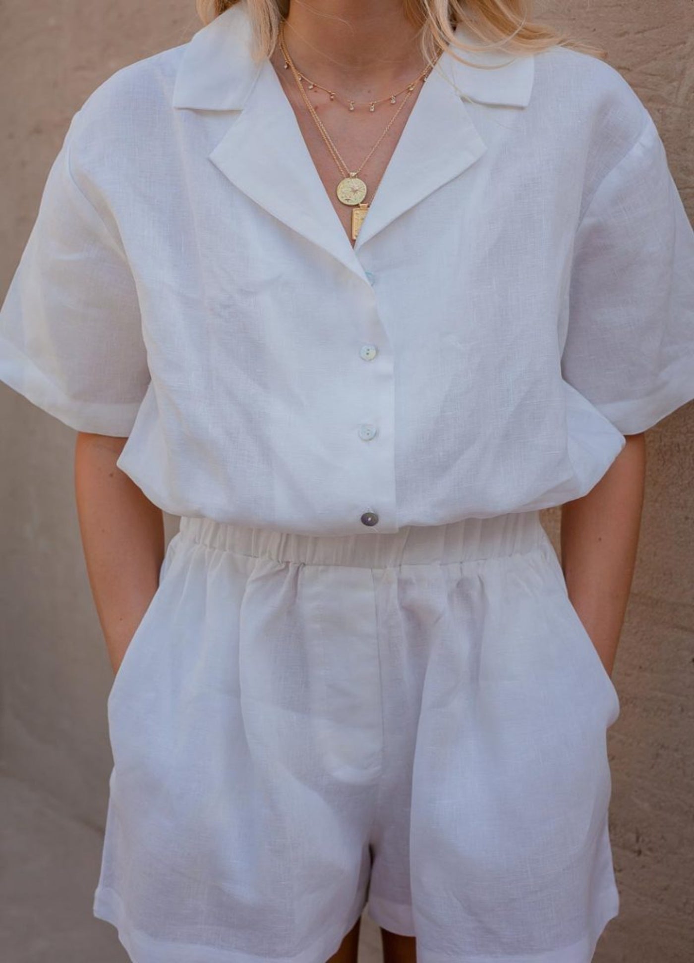 Blonde woman wearing white playsuit in 100% linen